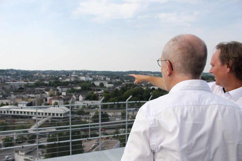 Zwei Männer auf dem Dach des Gaskessels betrachten die Stadt von oben.