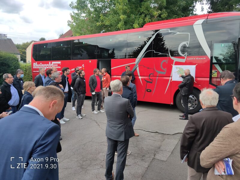 Ein Investor erklärt der Reise-Gruppe die Pläne für eine Wohnbaufläche.