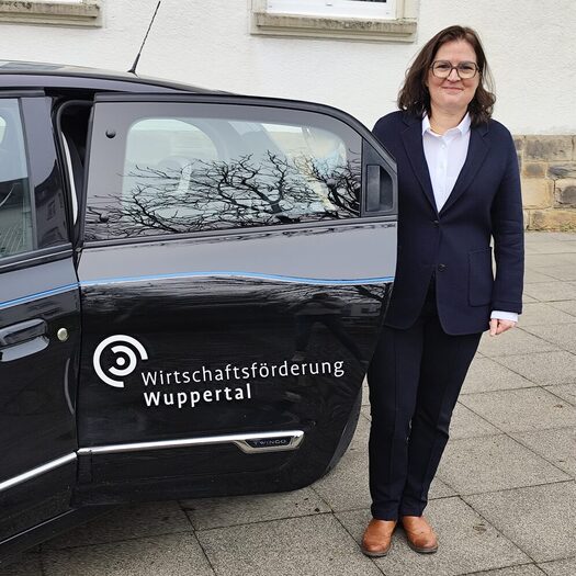 Eva Platz vor dem Firmenauto