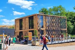 Besucher vor einem Musterhaus mit Solarfassade beim Solar Decathlon Europe