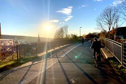 Fahrradfahrer sind im Sonnenuntergang auf der Nordbahntrasse unterwegs.