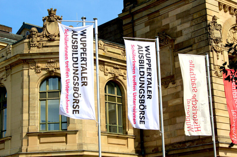 Fahnen kündigen die Ausbildungsbörse vor der Stadthalle an