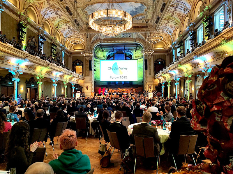 600 Gäste sitzen an Tischen in der Historischen Stadthalle und hören den Vorträgen auf der Bühne zu.