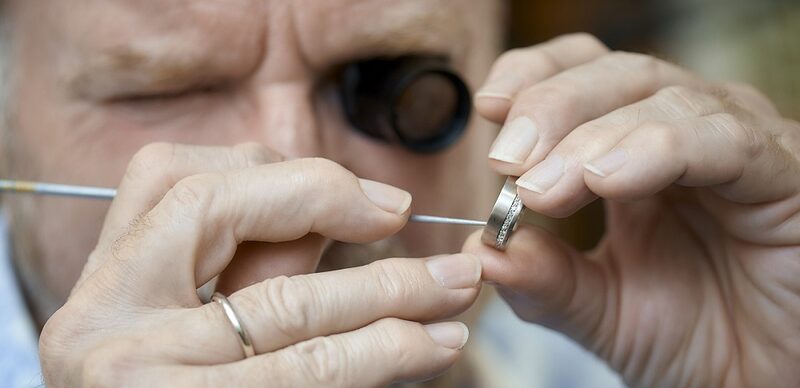 Juwelier Rehermann untersucht einen Silberring.