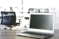 Ein Laptop steht auf einem Schreibtisch im Büro