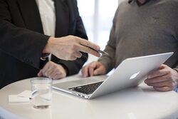 Zwei Männer gucken sich gemeinsam etwas auf dem Bildschirm eines Laptops an.
