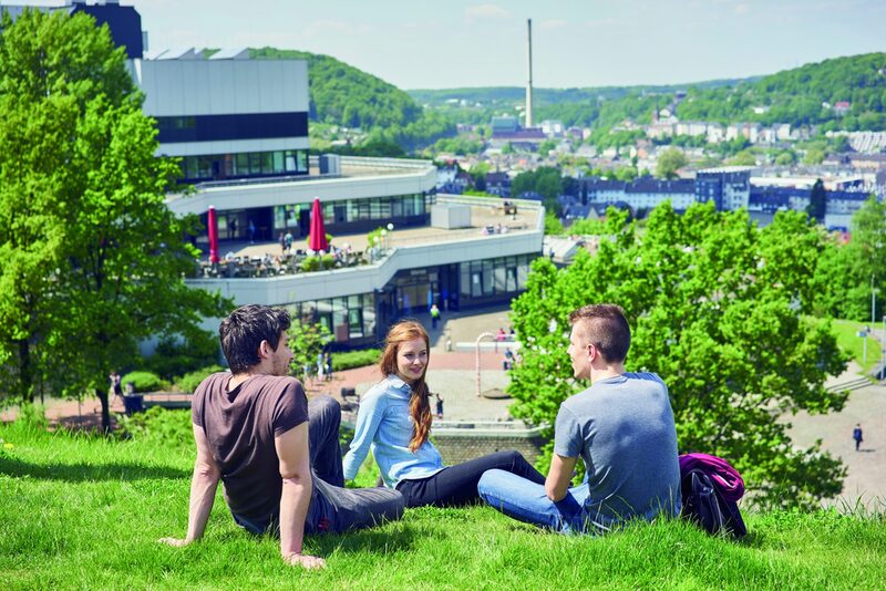 Studierende vor dem Mensa-Gebäude am Campus Grifflenberg.