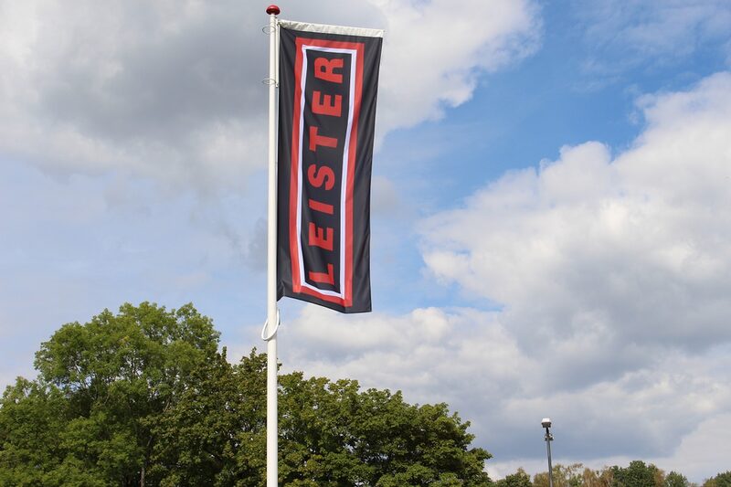 Flagge mit dem Leister-Schriftzug vor blauem Himmel