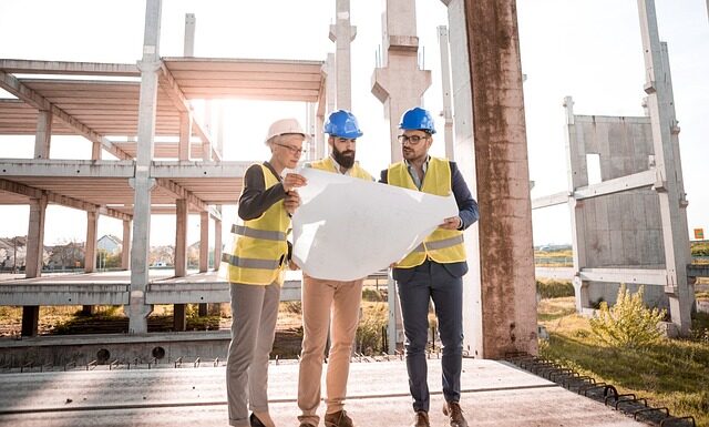 Architekten und Bauleiter sehen einen Plan auf der Baustelle an.