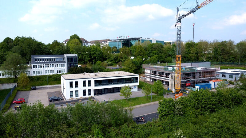 Bestandsgebäude der Ceteq GmbH neben eingerüstetem Neubau