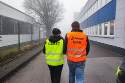 Ein Azubi mit Warnweste und der Aufschrift Jaeger-Team und einem Schüler mit Warnweste und der Aufschrift Gast.