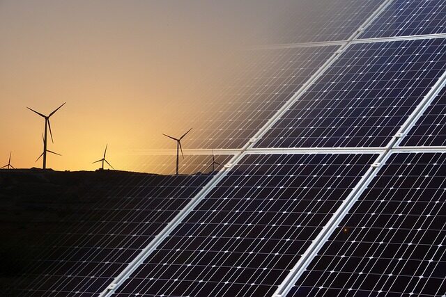 Windräder auf der linken Bildhälfte, Solarpanels auf der rechten.