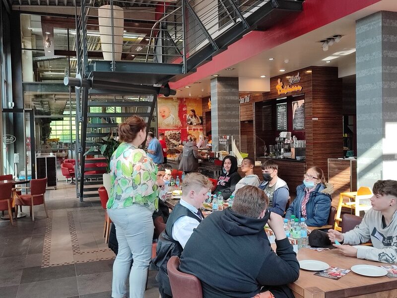 Eine Gruppe Schüler sitzt beim Frühstück in der Filiale der Bäckerei Dahlmann.