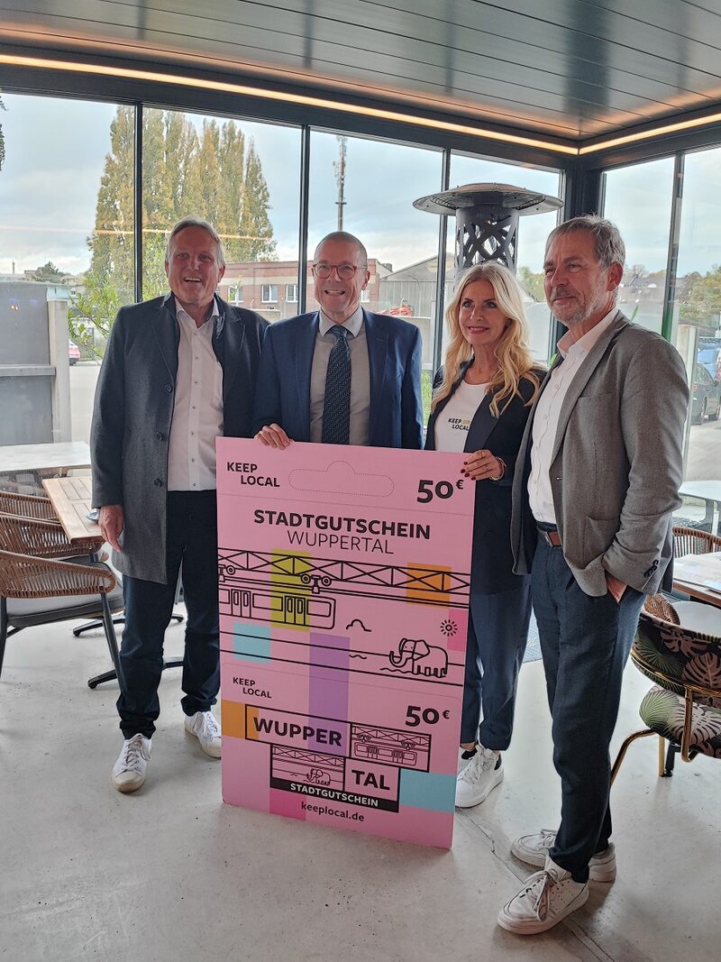 Uwe Schneidewind präsentiert mit den Projektmitgliedern einen Gutschien im XXL-Format.