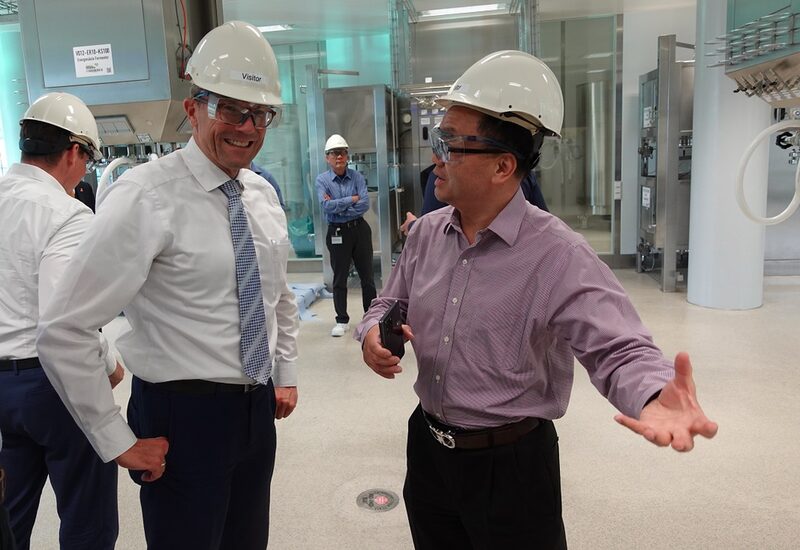 Chris Chen, CEO von WuXi, zeigt Oberbürgermeister Uwe Schneidewind die Produktionsräume.